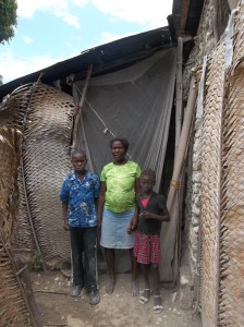 Michelet, Michelda & their mom in front of their home, July 2014.